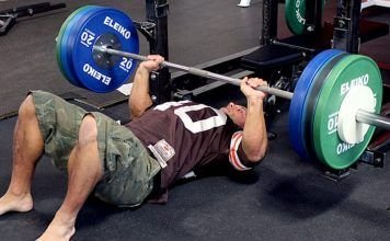 Chico realizando un Floor press en CrossFit con barra