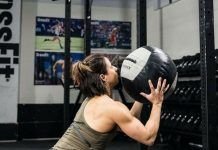 Chica realizando el KAREN WOD con un balon