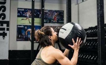 Chica realizando el KAREN WOD con un balon