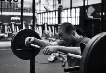 chico apoyado sobre una barra en crossfit