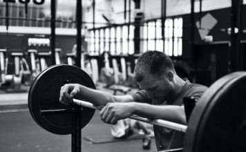 chico apoyado sobre una barra en crossfit