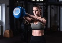 Chica realizando kettlebell swing o balanceo con pesa rusa