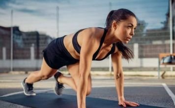 chica realizando mountain climbers o abdominales escaladores al aire libre