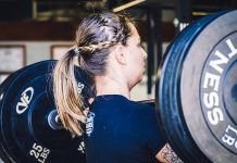 chica realizando cargad de fuerza o power clean en crossfit con barra