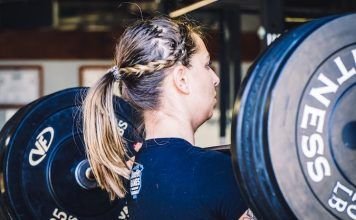 chica realizando cargad de fuerza o power clean en crossfit con barra