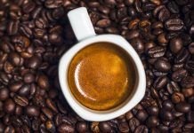 taza de cafe con cafeina sobre granos de cafe
