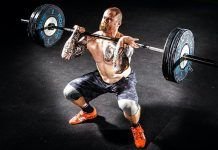 Hombre realizando sentadilla frontal con barra o front squat en crossfit