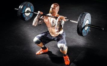 Hombre realizando sentadilla frontal con barra o front squat en crossfit