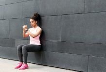 chica realizando sentadilla isometrica en pared