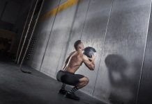 hombre realizando sentadilla de wall ball shot en crossfit